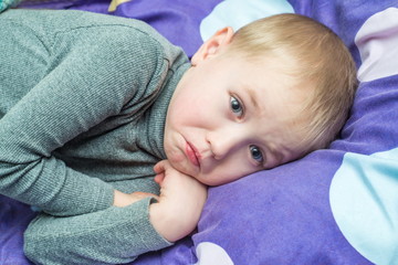 Boy Grip patient lying in bed with a thermometer