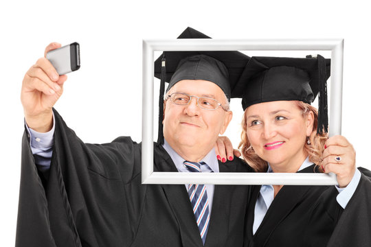 Mature couple taking a selfie behind picture frame