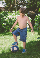 Obraz premium Blond boy stepping on a ball
