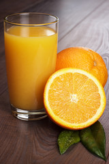 fresh orange and glass with juice on the table