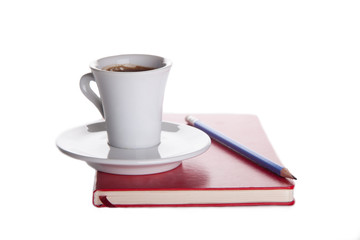 cup of coffee on a red notebook