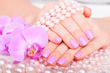 Obraz na płótnie Canvas Beautiful pink manicure pedicure. Well-groomed female hands spa