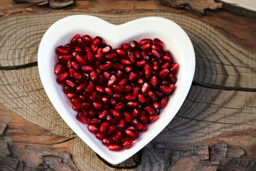 Pomegranate seeds on a plate in the form of heart