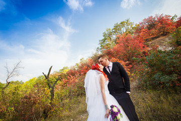 The groom, the bride, autumn park