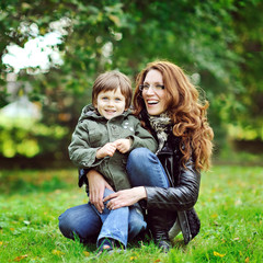 Fototapeta na wymiar Portrait of happy smiling mother and son in a park