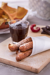fresh fried pumpkin churros with chocolate on cutting board