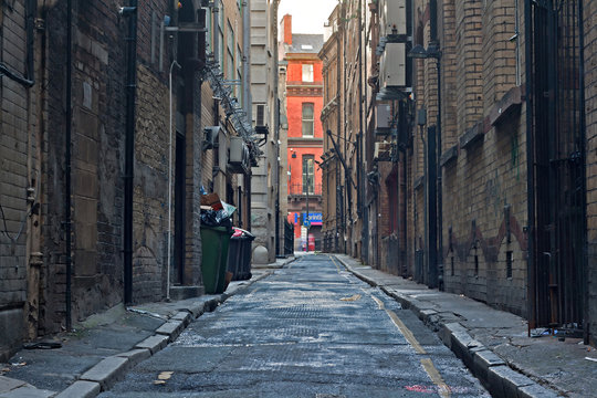 Fototapeta Looking down an empty inner city alleyway