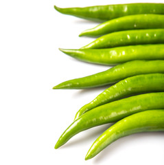 Green chili peppers over white background