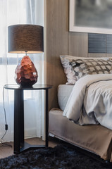 brown lamp on wooden round table in bedroom
