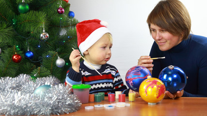 Fototapeta na wymiar mother with small boy paint christmas balls