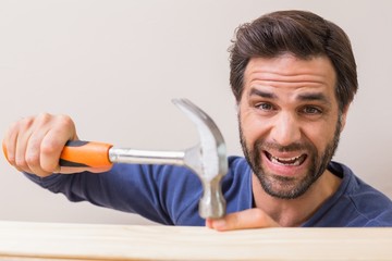 Casual man hammering his finger by accident