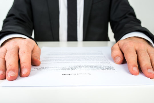 Businessman reading a document with focus to the text Terms and