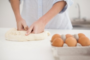 Fototapeta na wymiar Woman kneading dough on counter
