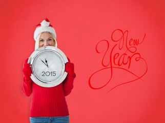 Composite image of happy festive blonde with clock