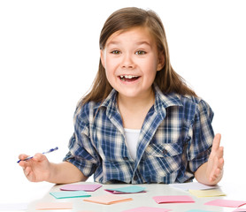 Girl is writing on color stickers using pen