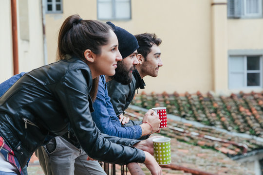 Coffee break. Three friends drinking a hot drink on the terrace