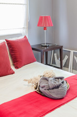 red pillow on bed in bedroom