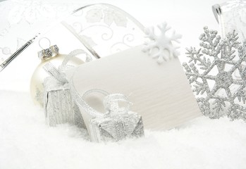Silver christmas decoration on snow with wishes card