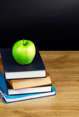 Books and apple in wood table