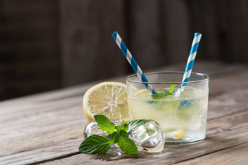 Lemonade with fresh lemon on wooden backgroun