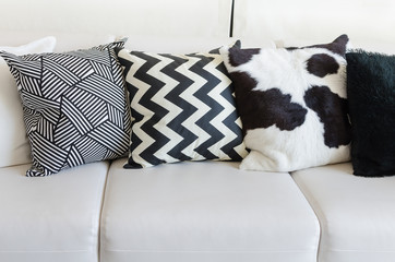 black and white pillows on white sofa in living room at home