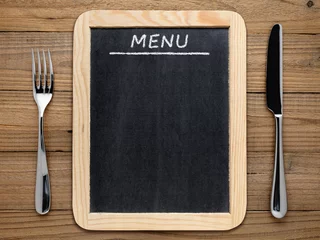 Fotobehang Fork, knife and blackboard menu on wooden background © Anatoliy Sadovskiy