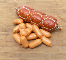 smoked sausage and cooked sausage closeup on wooden background