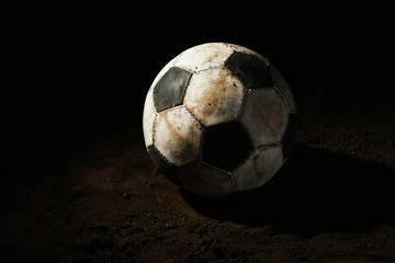 Soccer ball on ground on dark background