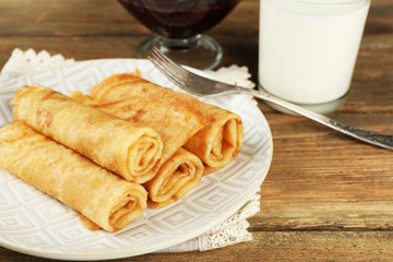 Plate of delicious pancakes with berry jam and glass of milk