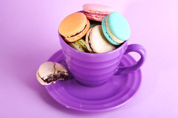 Fototapeta na wymiar Assortment of gentle colorful macaroons in colorful mug