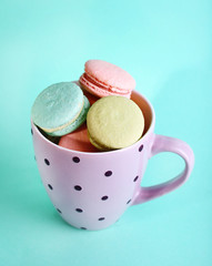 Assortment of gentle colorful macaroons in colorful mug