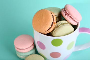 Assortment of gentle colorful macaroons in colorful mug