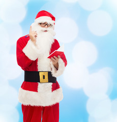 man in costume of santa claus with notepad