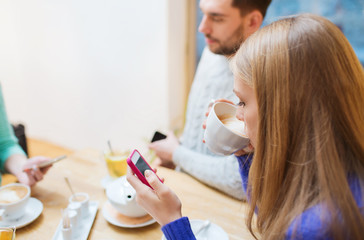 couple with smartphones drinking tea