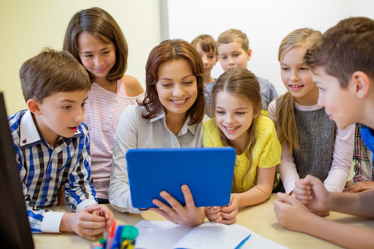 group of kids with teacher and tablet pc at school