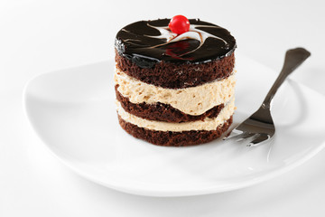 Yummy chocolate cupcake on white plate, close-up
