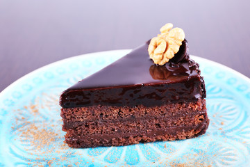 Delicious chocolate cake on plate on dark background