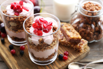 Healthy layered dessert with muesli and berries on table