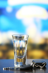 Glass of alcoholic drink and car key,