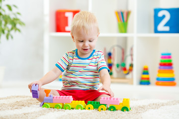 kid playing with building blocks at kindergarten