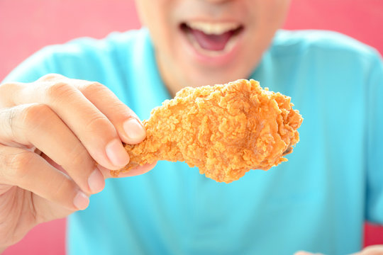 A Man With Opening Mouth About To Eat Deep Fried Chicken Leg Or