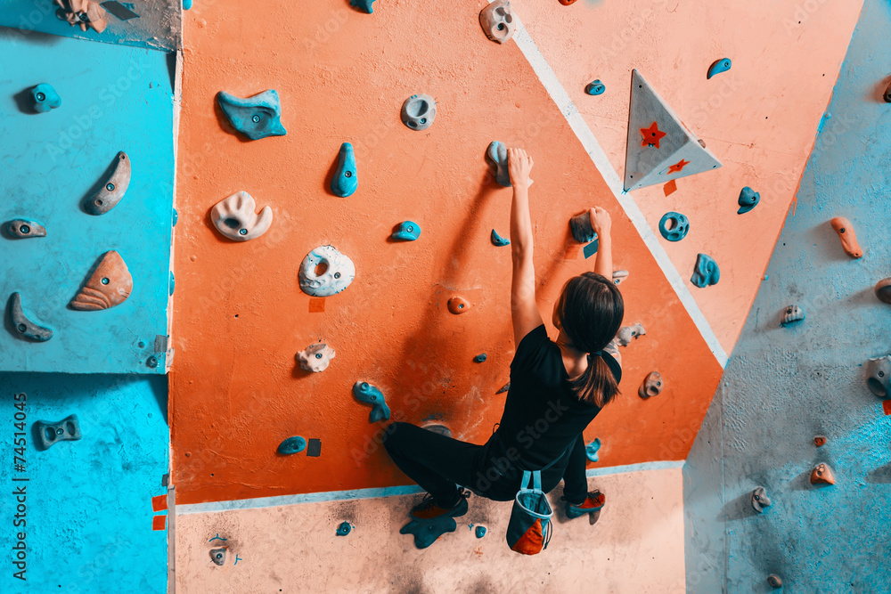 Poster woman climbing up on wall indoors