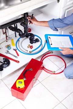 Plumber hands writing on clipboard.