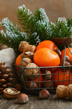 Xmas decoration wih tangerines, nuts and pine tree twigs