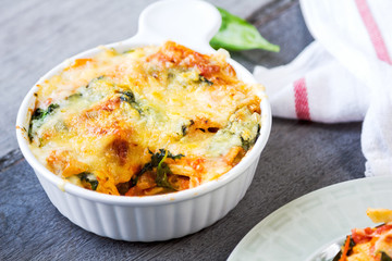 Baked pasta with spinach in tomato sauce