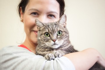 Young woman holding European shorthair cat