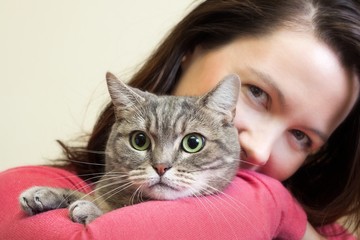 Young woman holding European shorthair cat