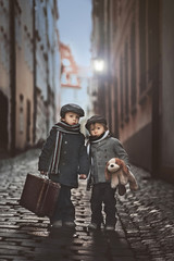 Two adorable boy, dressed in vintage style in the city center
