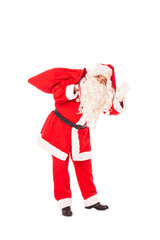 santa claus standing with gifts in hands and sack at his feet