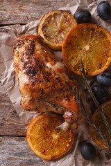 roasted rabbit leg with oranges and olives on a paper top view